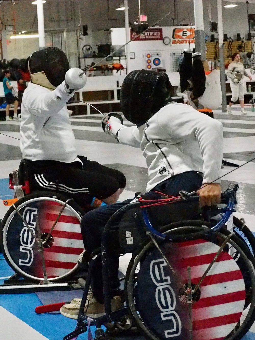 Wheelchair fencers in a parafencing bout